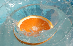 Кружок апельсина падает в воду