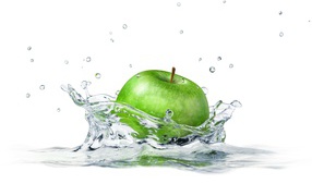Green apple falling into water