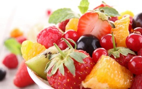 Кусочки спелых фруктов и ягоды на тарелке