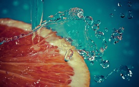 Вода льется на срез грейпфрута