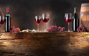 Красное вино и виноград на деревянной подставке