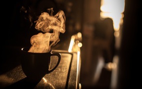 Steam from a cup of coffee at sunset
