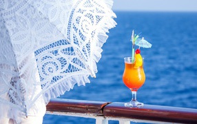 Сок у зонта на фоне моря