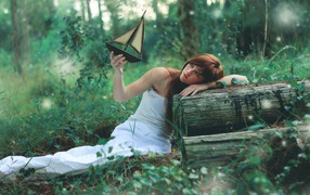 Девушка в белом платье держит в руке кораблик