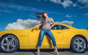 Девушка стоит у желтого автомобиля