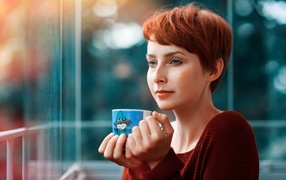 Девушка с короткими волосами пьет кофе