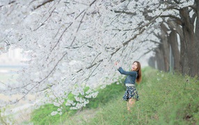 Азиатская девушка радуется весенним цветам