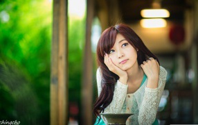 Азиатская девушка задумчиво смотрит вверх