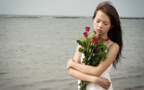 Азиатка держит в руках букет роз