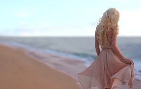 Блондинка в легком платье на пляже