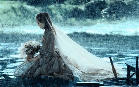 Невеста сидит на коленях под дождем