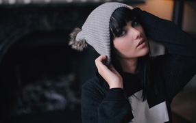 Брюнетка одевает вязаную шапочку