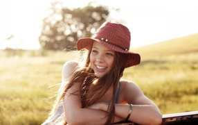 Веселая девушка в легкой красной шляпе