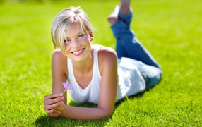 Милая блондинка на нежно зеленом газоне