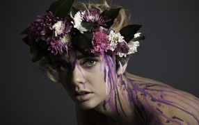 Цветочный венок на голове девушки и брызги краски по телу