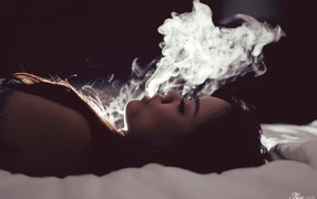 Девушка выпускает дым изо рта