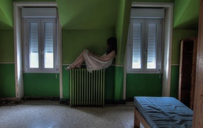 Девушка в ночной рубашке сидит на батарее