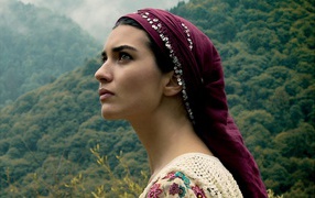 Девушка в красной косынке на фоне горного леса