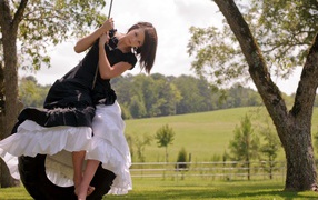 Девушка в черном платье на качелях