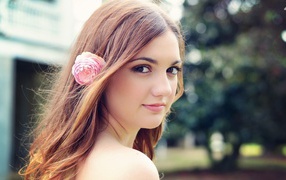 Девушка модель с розовым цветком в волосах