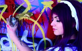 Девушка рисует граффити на стене