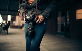 Девушка фотограф с профессиональным фотоаппаратом Canon