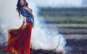 Девушка позирует на фоне дыма