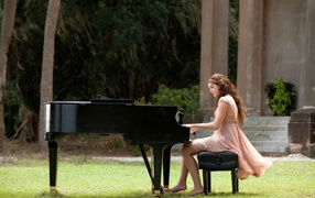 Девушка сидит за роялем на улице
