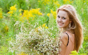 Девушка улыбается, держа в руках букет ромашек