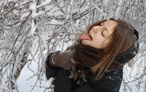 Девушка пробует сосульку на вкус