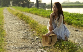 Девушка со шляпой присела на дорогу