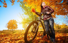 Девушка с велосипедом на осенней прогулке