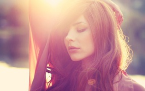 Девушка с каштановыми волосами в лучах солнца