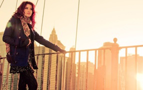 Девушка с красными волосами стоит у поручня