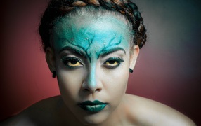 Зеленая краска на лице у девушки