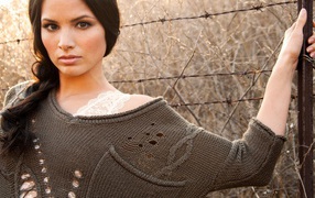 Девушка у забора из колючей проволоки