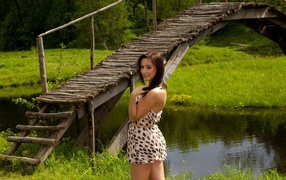 Девушка у деревянного моста через реку