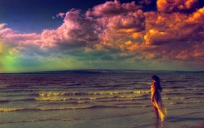 Девушка входит в волны прибоя