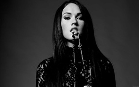 Девушка держит в зубах украшение