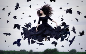 The girl in a black dress soars among crows