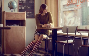 Девушка в полосатых чулках смотрит в окно