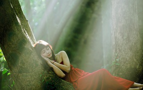 Девушка прилегла отдохнуть на стволе дерева