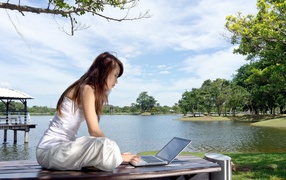 Девушка с ноутбуком у озера