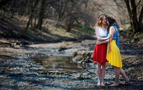 Две девушки в ярких платьях в чаще леса