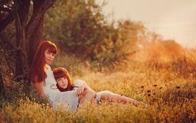 Две рыжих девушки отдыхают у дерева