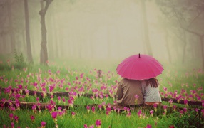 Two sitting under an umbrella