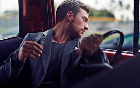 Мужчина за рулем смотрит в окно автомобиля