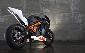 Черный мотоцикл KTM RC8 у серой стены