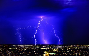 Lightning in a blue sky over night city