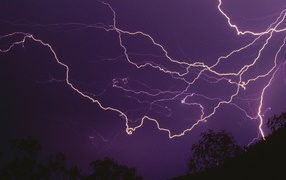 Молнии в фиолетовом небе ночью